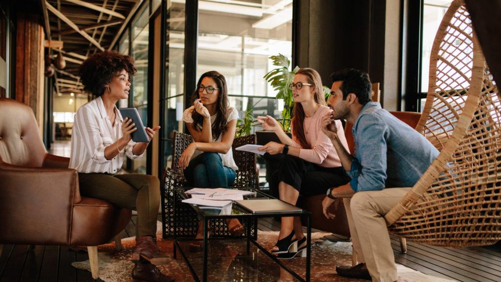 Pessoas sentadas em uma sala de reunião conversando